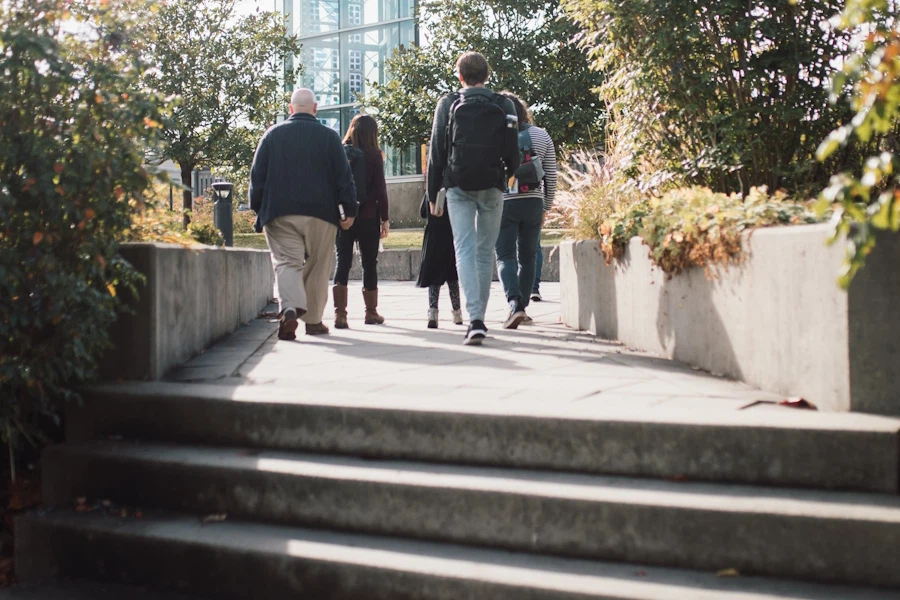 A varied group of people walks away from camera into a slightly hazy distance