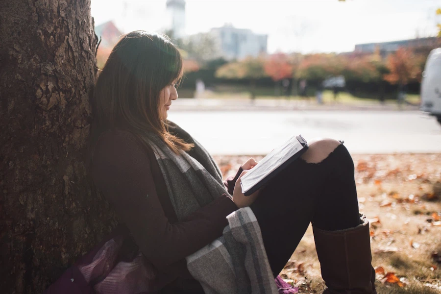 A student reading the Bible under a tree