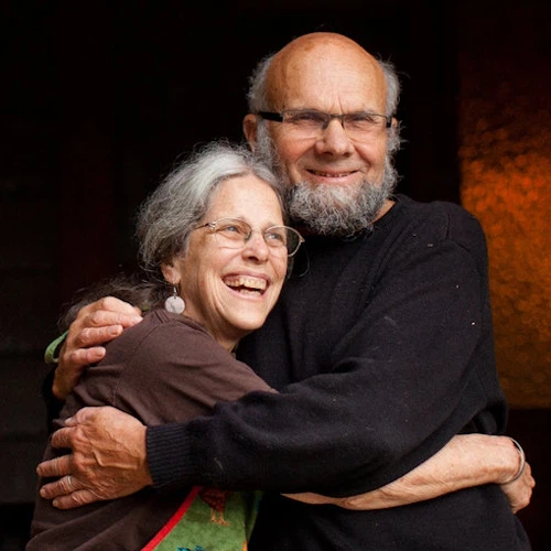 Mary Ruth and Loren Wilkinson embrace in front of a porch swing.